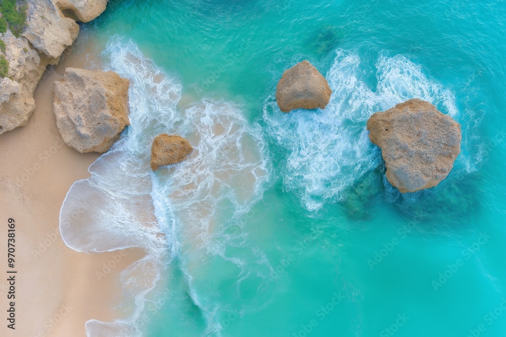 Aerial view of turquoise ocean waves crashing against large rocky formations on a sandy coastline, showcasing the dynamic interaction between water and rocks Aerial view of turquoise ocean waves crashing against large rocky formations on a sandy coastline, showcasing the dynamic interaction between water and rocks