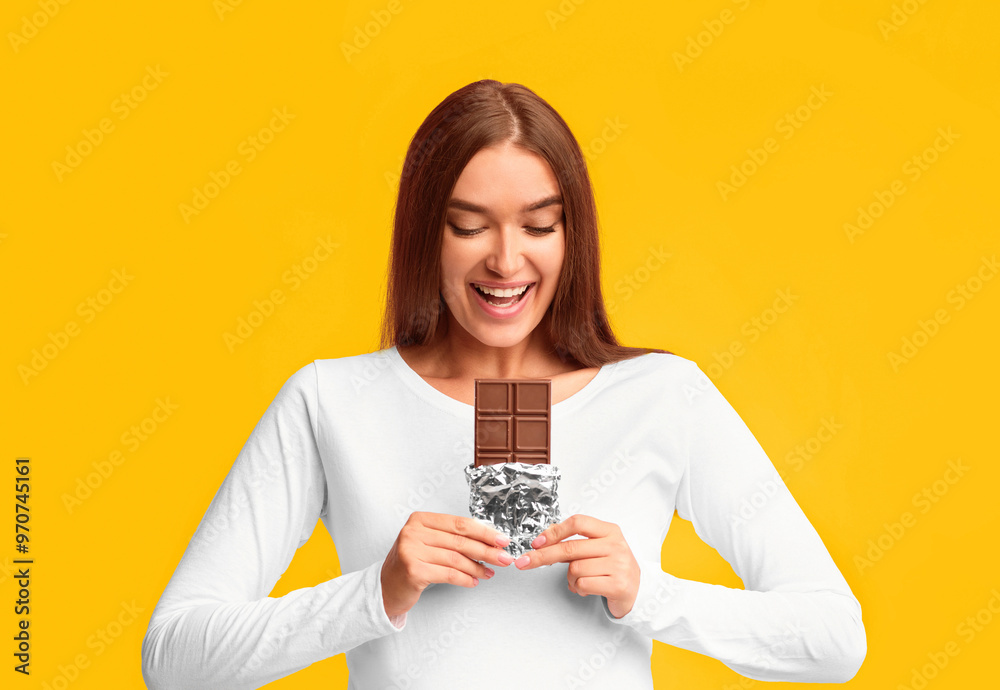 Pregnant Woman Eating Chocolate Standing On Pink Studio Background. Pregnancy Nutrition Concept Pregnant Woman Eating Chocolate Standing On Pink Studio Background. Pregnancy Nutrition Concept