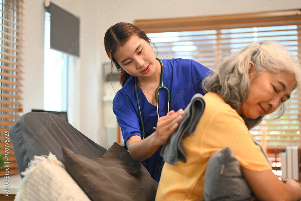 Physical therapist doing back percussion on a senior patient to help loosen and drain secretions from her lungs Physical therapist doing back percussion on a senior patient to help loosen and drain secretions from her lungs