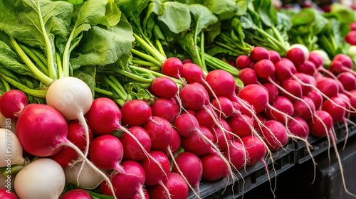 A display of colorful radishes (Raphanus sativus) with their bright red bulbs and green leaves photo