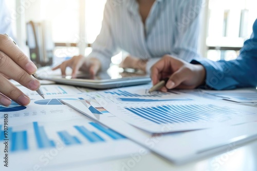 Two individuals reviewing documents and calculating figures during a business meeting