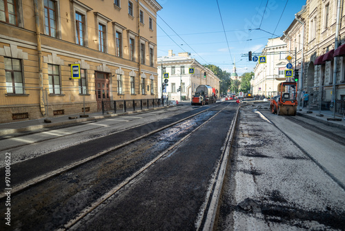 Asphalt removed for extensive repair of tram tracks and road in city. Road roll working with concrete, major roadwork, updating infrastructure, improving transportation, urban development, renovation