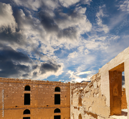 Qasr Kharana (Kharanah or Harrana)-- desert castle in eastern Jordan (100 km of Amman). Built in 8th century AD to be used as caravanserai, a resting place for traders. Against the sky with clouds photo