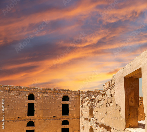 Qasr Kharana (Kharanah or Harrana)-- desert castle in eastern Jordan (100 km of Amman). Built in 8th century AD to be used as caravanserai, a resting place for traders. Against the sky with clouds photo