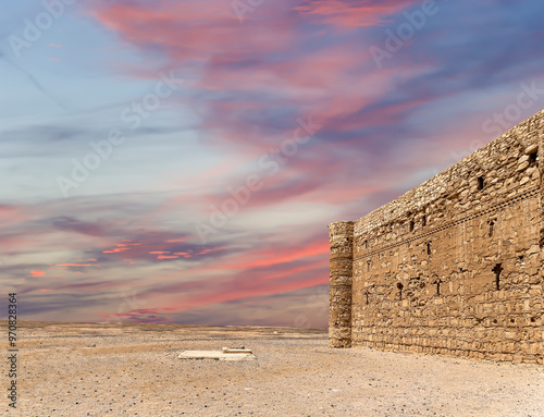 Qasr Kharana (Kharanah or Harrana)-- desert castle in eastern Jordan (100 km of Amman). Built in 8th century AD to be used as caravanserai, a resting place for traders. Against the sky with clouds photo