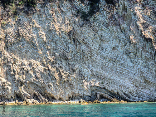 Outcrop of folded carbonate sedimentary rock at the coast in southern Albania photo