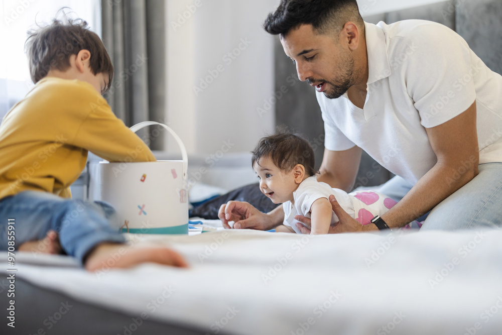 Young father playing with his two little kids at home
Young father playing with his two little kids at home