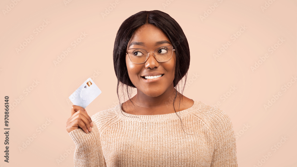 Smiling Black Woman Holding Credit Card Looking Aside Thinking About Something Standing Over Pink Background In Studio. Panorama Smiling Black Woman Holding Credit Card Looking Aside Thinking About Something Standing Over Pink Background In Studio. Panorama