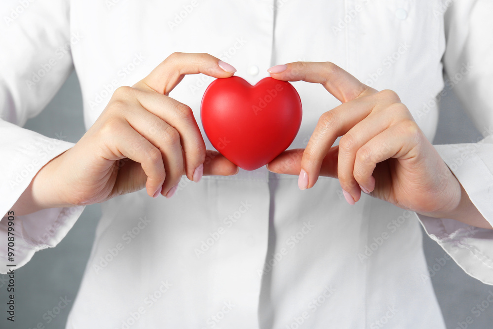 Doctor holding red heart on grey background, closeup Doctor holding red heart on grey background, closeup