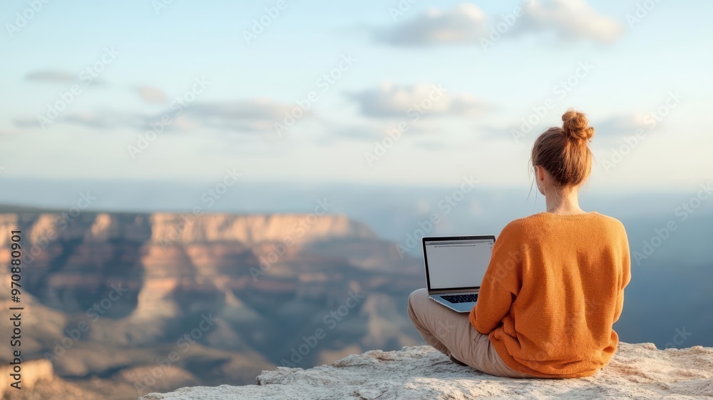 Fototapeta premium Remote worker with a laptop on a cliffside bench, overlooking vast landscapes, symbolizing the freedom of digital nomadism, remote work, freedom
