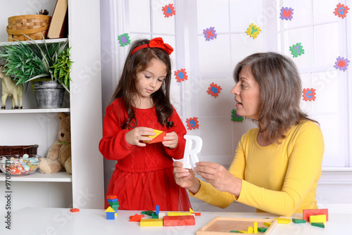 Proper articulation therapy for girl . Cute little child  at speech therapist office photo