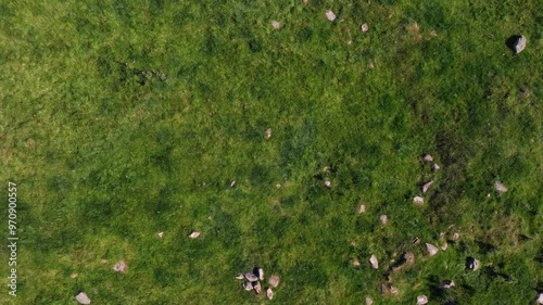 Beltany Stone Circle, County Donegal, Ireland, June 2023. Drone in Bird's Eye view ascends while rotating clockwise above the ancient monument surrounded by rural fields on a bright sunny day. photo