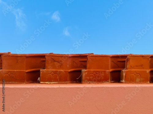 House wall, view towards blue sky, roof tiles 