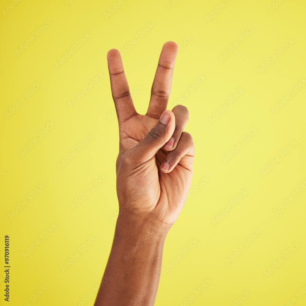 Naklejka premium Closeup, model and hand with peace, sign and support with agreement, respect and review on yellow studio background. African person, mockup and fingers for feedback, vote and emoji with icon and like