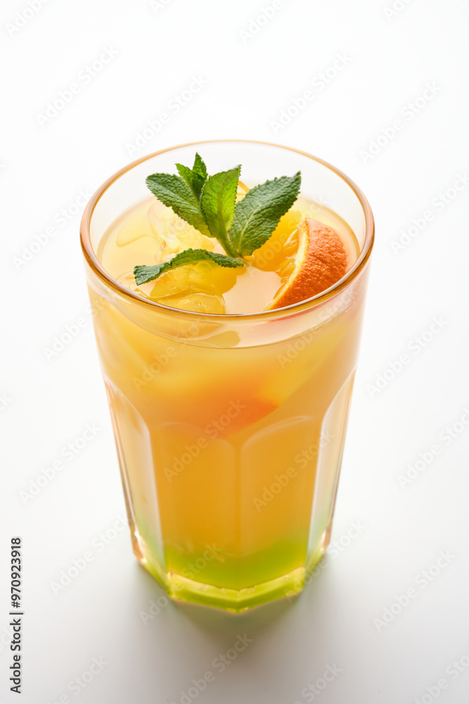 Refreshing tropical fruit cocktail with mint garnish served in a tall glass against a plain background Refreshing tropical fruit cocktail with mint garnish served in a tall glass against a plain background