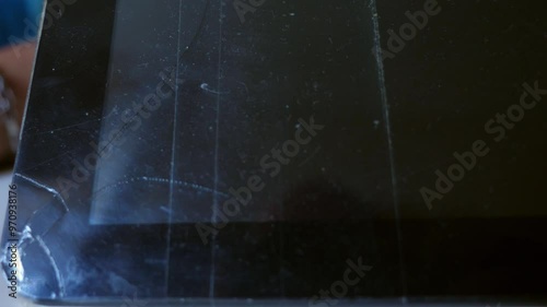 Close-up of a tablet that has fallen and shattered on the ground. Focus on the broken screen and surface damage photo
