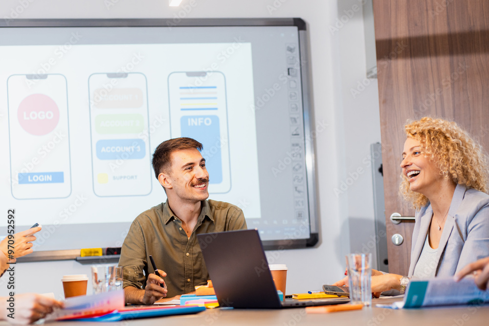 Group of business people sitting in a meeting room discussing a design for a smartphone application. Group of business people sitting in a meeting room discussing a design for a smartphone application.