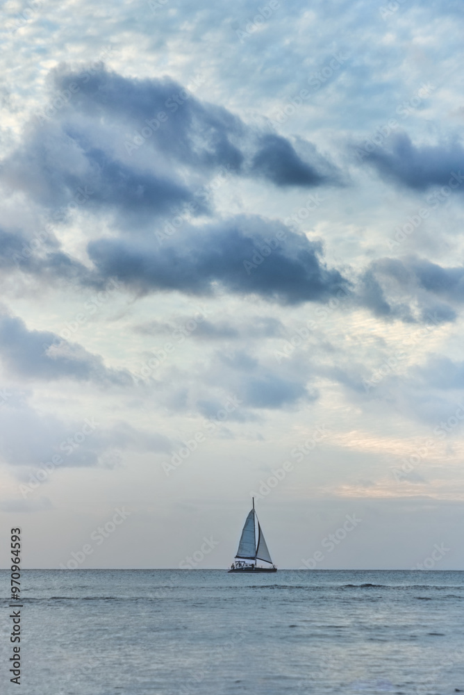 Fototapeta premium Beautiful sunset over the ocean and a small yacht 