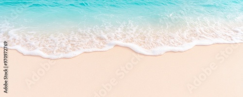 Beautiful tropical white sand beach with foam waves and a transparent sea, seen from above.