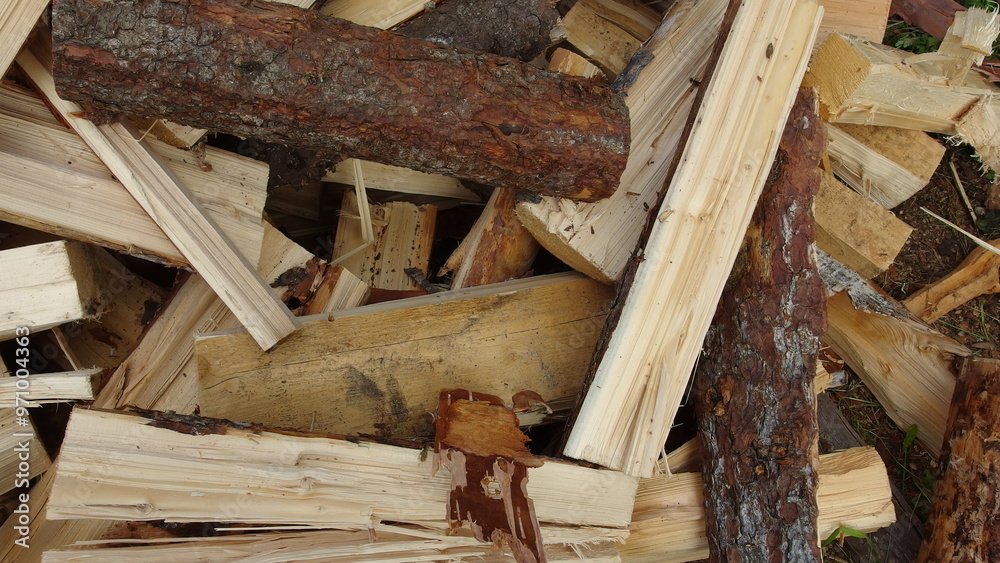 a pile of chopped firewood. The pieces of wood vary in size and shape, with some having bark still attached. The wood appears to be freshly cut, as indicated by the light color a pile of chopped firewood. The pieces of wood vary in size and shape, with some having bark still attached. The wood appears to be freshly cut, as indicated by the light color