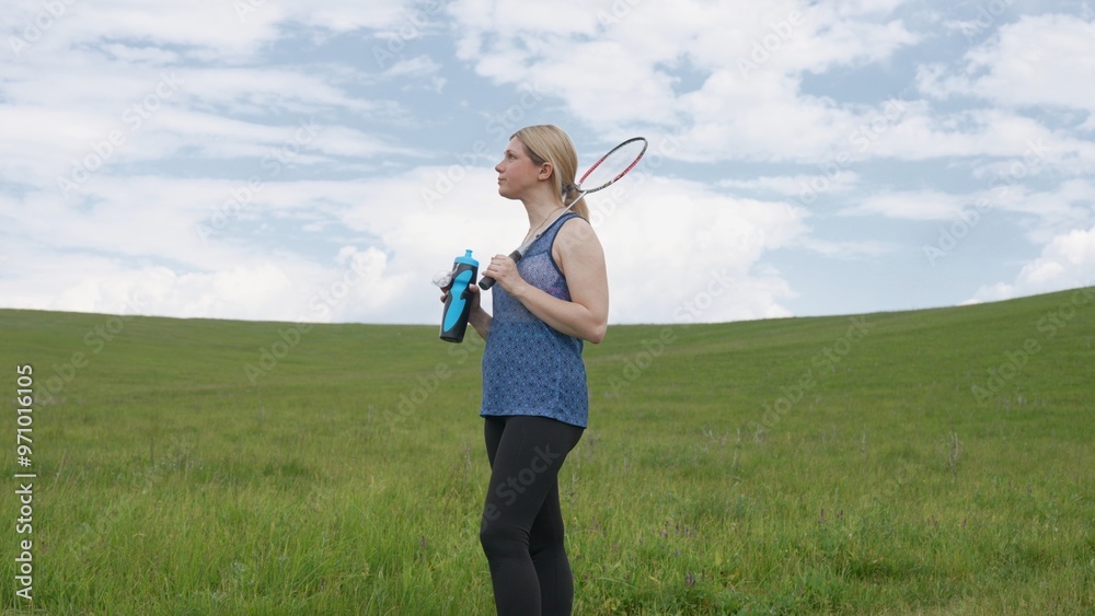 Active Woman Pausing for Hydration in a Lush Field Active Woman Pausing for Hydration in a Lush Field