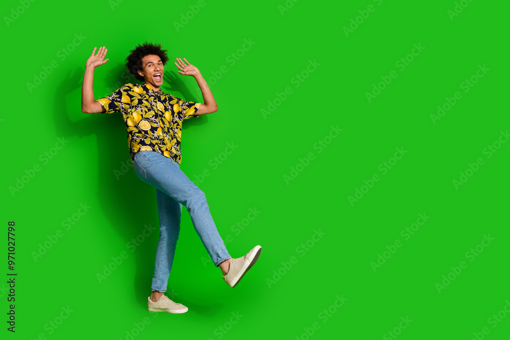 Photo of glad funny optimistic man wear stylish print clothes dance empty space isolated on green color background