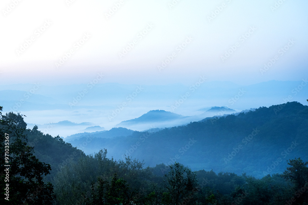 Panorama of sea of clouds around mountain peaks at dawn Panorama of sea of clouds around mountain peaks at dawn
