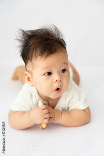 a baby laying on the floor with a tooth in his mouth photo