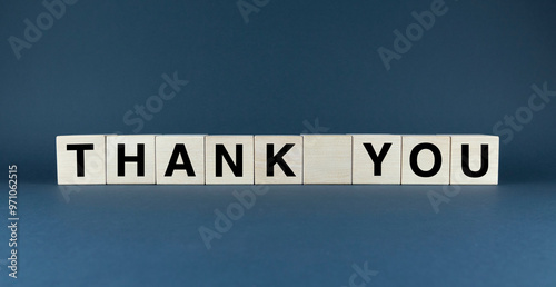 Thank You spelled out on wooden cubes against a dark blue background