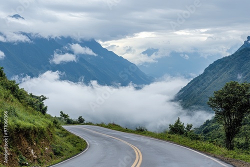Scenic winding road through mountains, surrounded by lush greenery and misty clouds, perfect for travel and adventure themes.