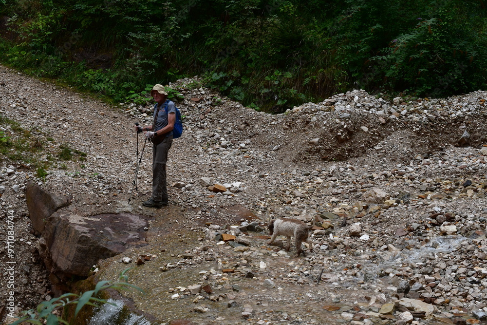 Mann und sein Lagotto Romagnolo Hund wandern in Südtirol