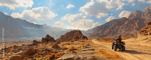 Adventurous traveler on an ATV rides through rugged desert terrain under a vast, panoramic sky. off-road vehicles theme.