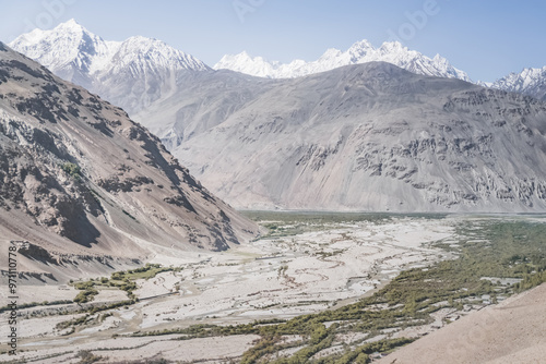 Valley Wakhan corridor and the confluence of the Panj and Pamir rivers surrounded by high rocky mountains with snow in Tajikistan, landscape on Pamra in the Tien Shan Mountains on the Pamir Highway photo