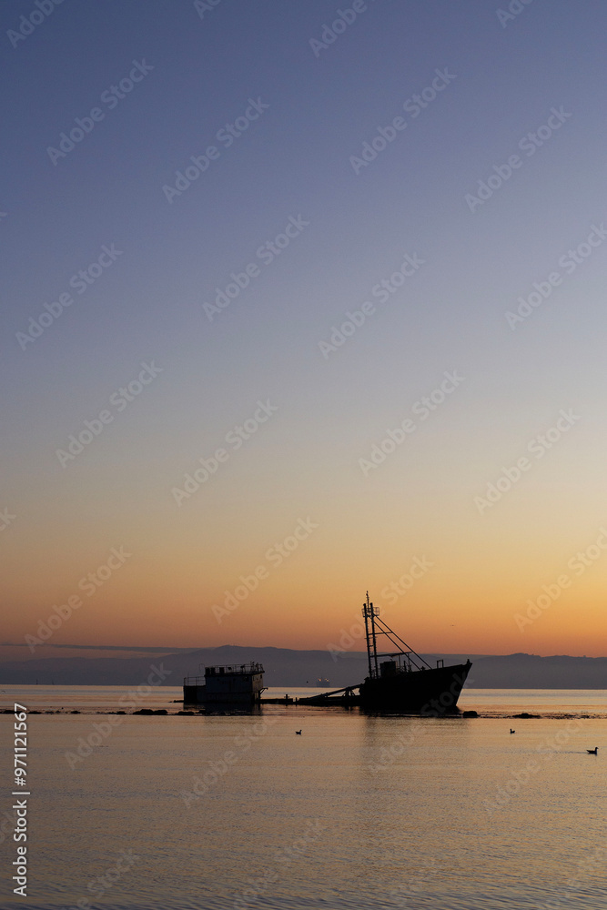 a sunken ship on a beach at sunset in Chile a sunken ship on a beach at sunset in Chile