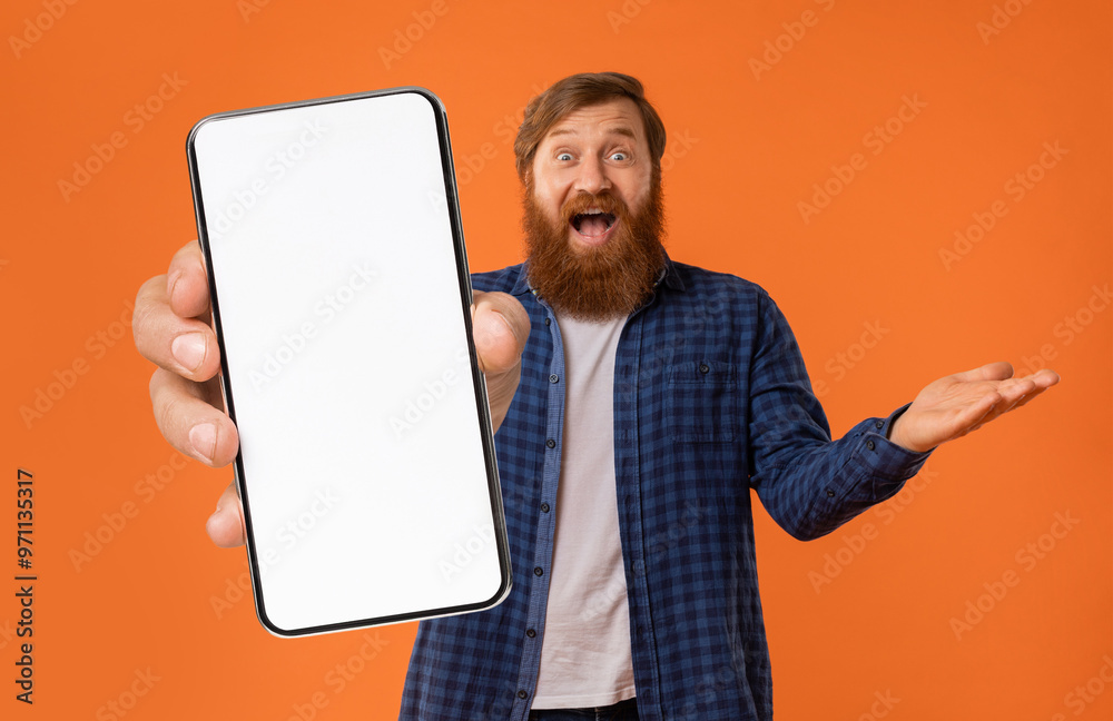 A joyful man with a beard enthusiastically holds up a smartphone with a blank screen, gesturing excitedly against a bright orange background, inviting interaction with a smile. A joyful man with a beard enthusiastically holds up a smartphone with a blank screen, gesturing excitedly against a bright orange background, inviting interaction with a smile.