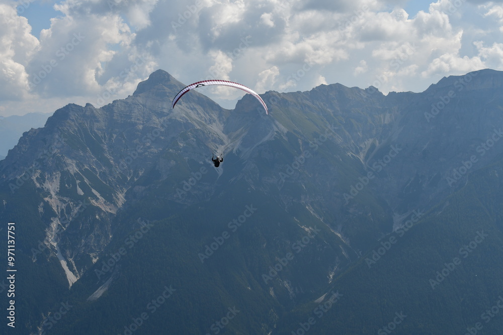 Ein Gleitschirmflieger über dem Stubaital in Tirol