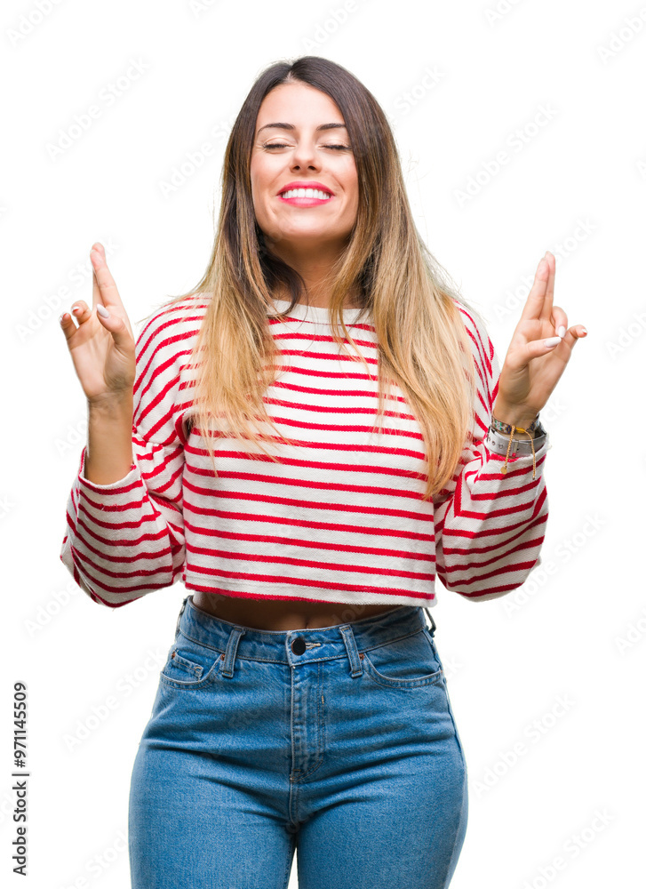 Young beautiful woman casual stripes winter sweater over isolated background smiling crossing fingers with hope and eyes closed. Luck and superstitious concept. Young beautiful woman casual stripes winter sweater over isolated background smiling crossing fingers with hope and eyes closed. Luck and superstitious concept.