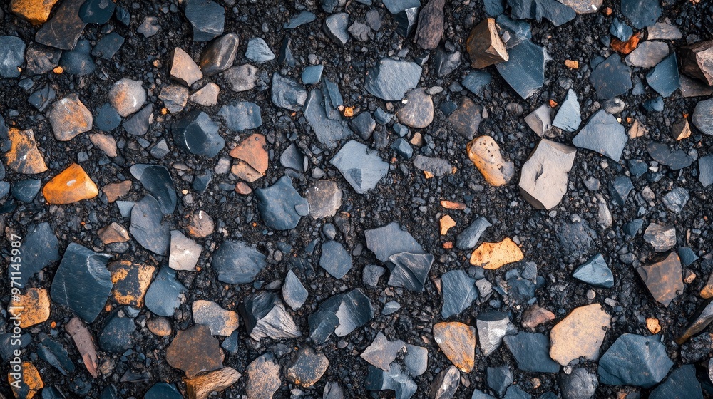 A textured landscape of smooth, jagged stones in shades of gray, black, and rust. A textured landscape of smooth, jagged stones in shades of gray, black, and rust.