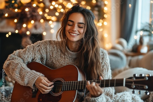 A woman enjoys her guitar-playing session in a room decorated with festive lights, reflecting celebration, joy, and musical passion during a serene evening indoors. photo