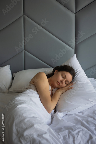 A young woman is sleeping peacefully in a bed