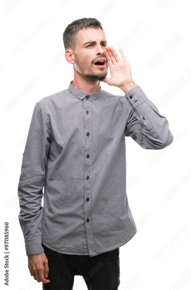 Young hipster man shouting and screaming loud to side with hand on mouth. Communication concept. Young hipster man shouting and screaming loud to side with hand on mouth. Communication concept.