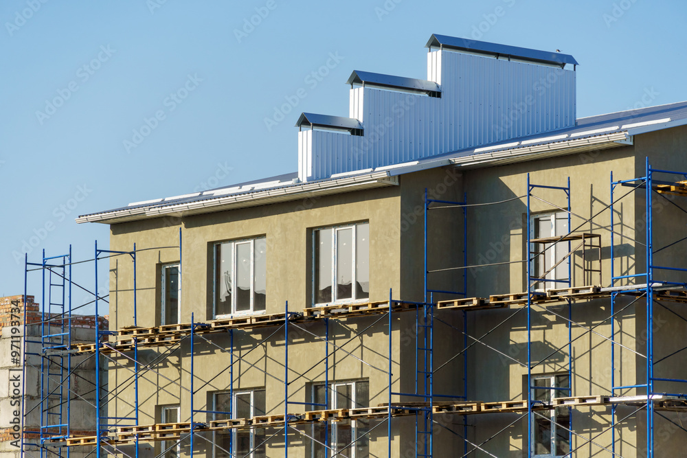 a construction site with a house under construction against the sky