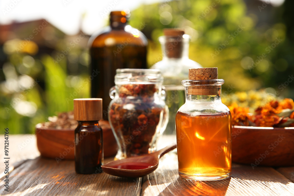 Different tinctures and ingredients on wooden table outdoors Different tinctures and ingredients on wooden table outdoors