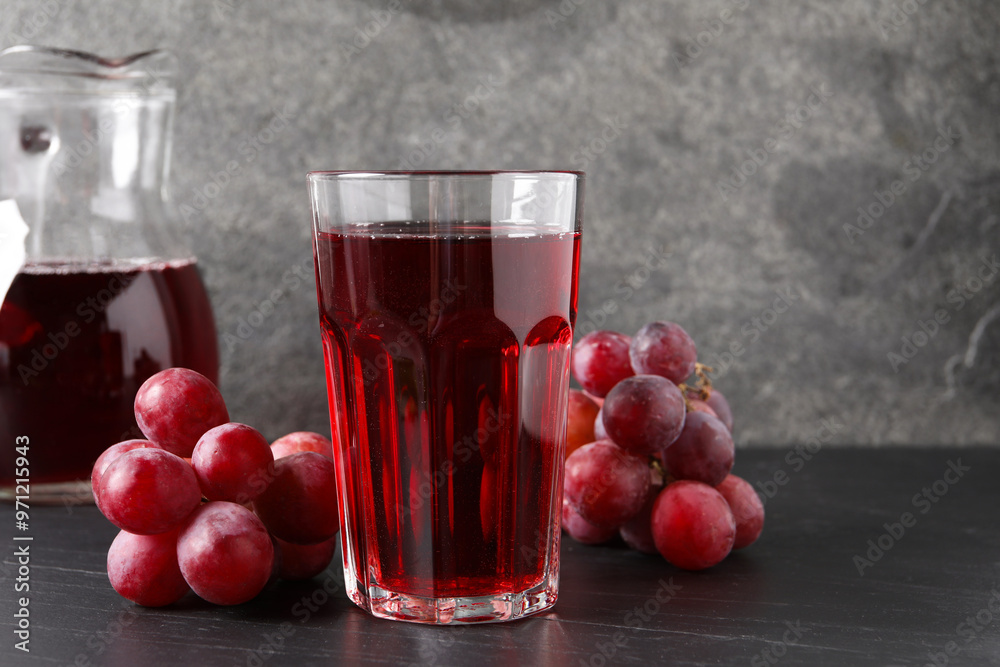 Tasty grape juice and berries on dark textured table, closeup Tasty grape juice and berries on dark textured table, closeup