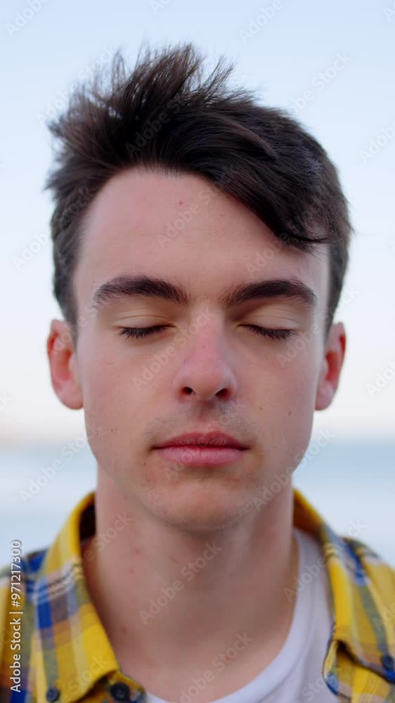 Concentrated boy opening the eyes and looking at camera. Meditation and mental health concept. Concentrated boy opening the eyes and looking at camera. Meditation and mental health concept.