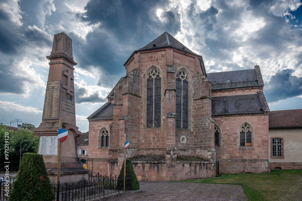 Fototapeta premium Étival-Clairefontaine, France - 09 01 2024: Saint-Pierre Abbey. Panoramic view outside of the back of the abbey and the war memorial.