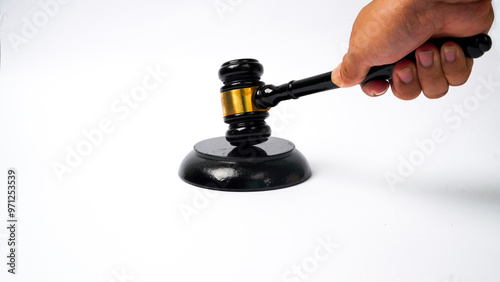 close-up of hand holding hammer while making decision isolated on white background. Auction hammer with wooden stand. Concept of law and justice. photo