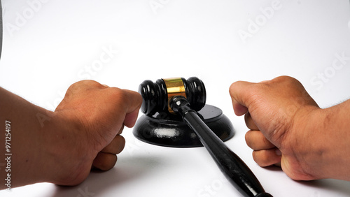 close-up of judge's wooden gavel on table and hand gesture hitting the table isolated on white background. Auction gavel with wooden stand. Angry concept of accepting law and justice.