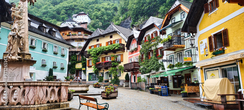 Fotografia A charming town square in Hallstatt, Austria, with vibrant, colorful buildings adorned with balconies and flowers