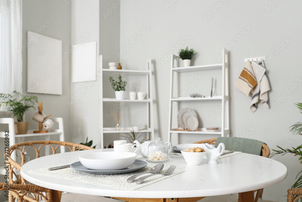 Served dining table and shelving units in interior of stylish kitchen Served dining table and shelving units in interior of stylish kitchen